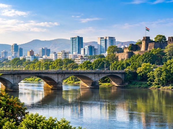 Pune city skyline beside a river and an old stone arch bridge